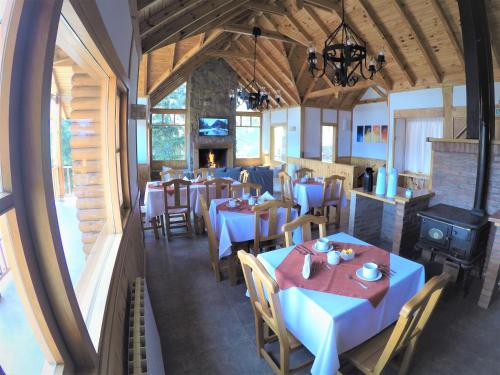 un comedor con mesas y sillas en un restaurante en Hostería Bärenhaus en San Martín de los Andes