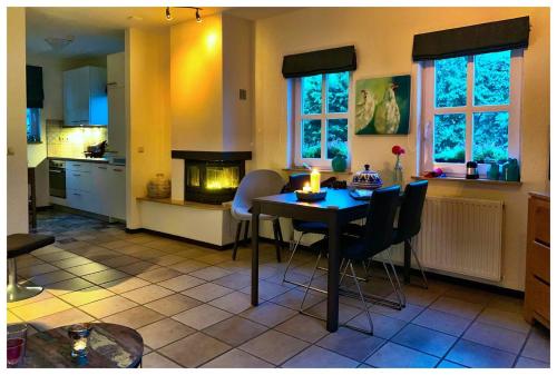 a kitchen with a table and chairs and a fireplace at Huis in de natuur in Epen