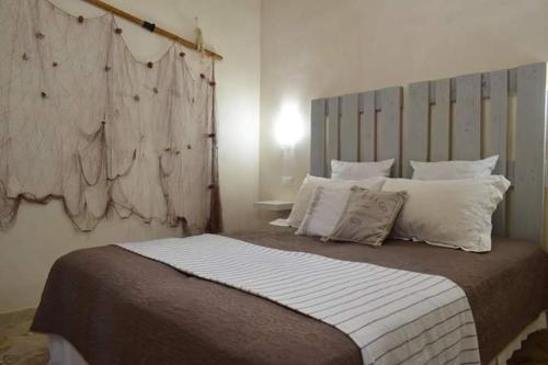 ein Schlafzimmer mit einem großen Bett mit weißen Kissen in der Unterkunft F&L house in Polignano a Mare