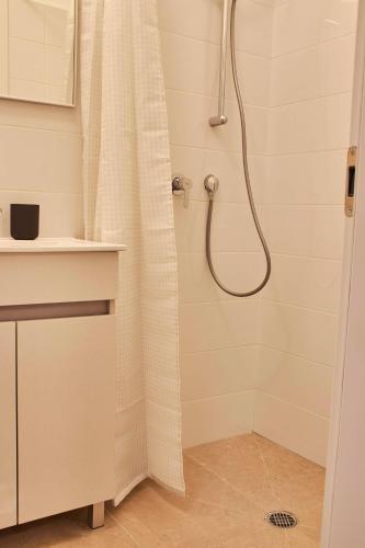 a shower with a shower curtain in a bathroom at Roza Apartment in Tel Aviv