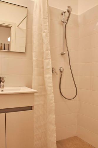 a shower with a shower curtain in a bathroom at Roza Apartment in Tel Aviv