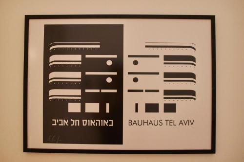 a framed picture of a poster on a wall at Roza Apartment in Tel Aviv