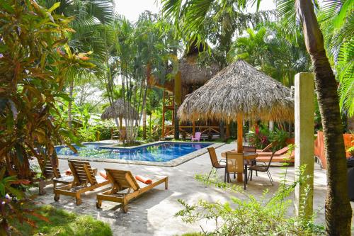 a resort with a swimming pool with chairs and a table at Fuego Lodge in Santa Teresa Beach