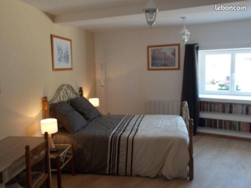um quarto com uma cama, uma mesa e uma janela em Le gîte du bois sebille em Verdelot