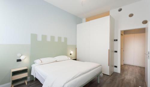 een witte slaapkamer met een wit bed en een deur bij Casa Piazza Erbe 70 mq in Riva del Garda