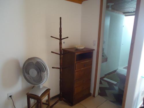 Habitación con ventilador y tocador de madera. en APARTAMENTOS ALTOS DA GRUPIARA - DIAMANTINA/MG, en Diamantina