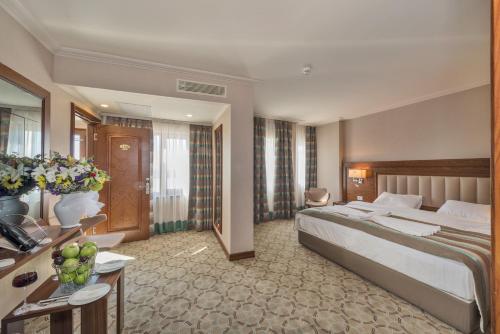 a hotel room with a large bed and a desk at Bekdas Hotel Deluxe & Spa in Istanbul