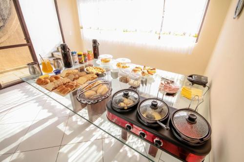 een keuken met een tafel met eten erop bij Suites Natalia Enseada in Guarujá
