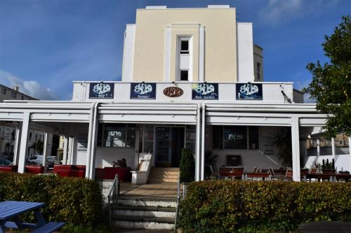 a white building with blue signs on it at The Portland Hotel in Folkestone