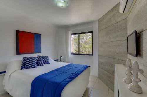 a bedroom with a bed with a blue blanket on it at Pousada Saint Paul in Florianópolis