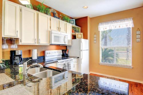 a kitchen with a sink and a refrigerator at Beach Club Condos in Padre Island