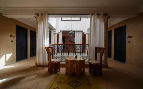 a room with a table and chairs in a building at Riad Les Jardins de Tafraoute in Foum Mharech