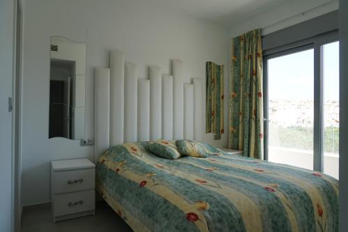 a bedroom with a bed and a large window at Villa Amalia 54 in Torrevieja
