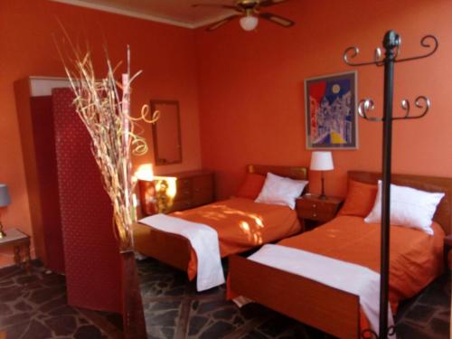 - 2 lits dans une chambre aux murs orange dans l'établissement LOFT GREEN, à La Laguna