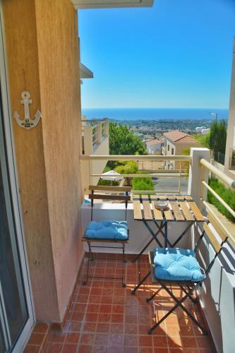 a balcony with chairs and a table and a view of the ocean at PMP Adamia Apartments in Peyia