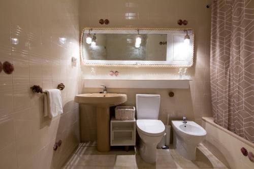 a bathroom with a sink and a toilet and a mirror at Casa da Praia in Viana do Castelo
