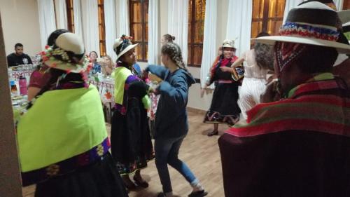 a group of people in costumes dancing in a room at Casa Treveris - Non profit Hostel in Sucre