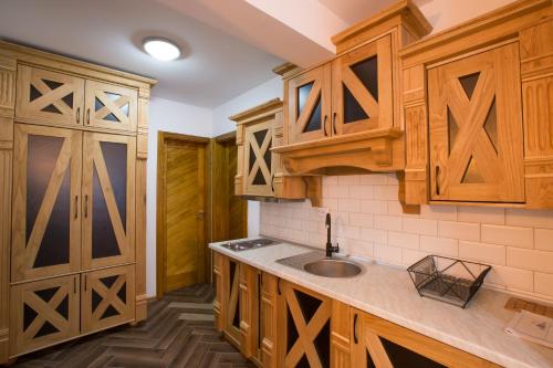 a kitchen with wooden cabinets and a sink at Jahorinski IZLOG in Jahorina