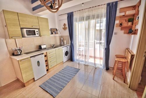 a kitchen with a refrigerator and a counter top at PMP Adamia Apartments in Peyia