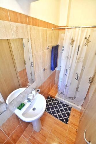a bathroom with a sink and a shower and a toilet at PMP Adamia Apartments in Peyia