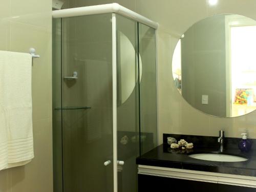 La salle de bains est pourvue d'une douche, d'un lavabo et d'un miroir. dans l'établissement Apartamento no Corais de Búzios por Carpediem, à Nísia Floresta
