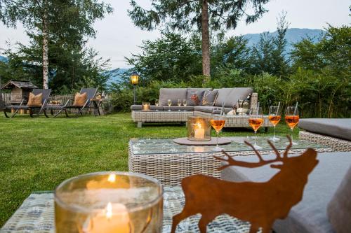 a table with glasses of wine and a deer on it at Chalet Waldhaus Rappakopf in Tschagguns