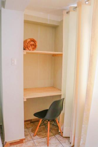 a green chair sitting in a closet with shelves at RUMIQOLQA Machupicchu Hotel in Machu Picchu
