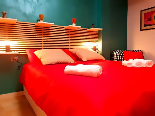 un letto rosso con asciugamani in una camera da letto di Notti Rosa B&B a Melfi