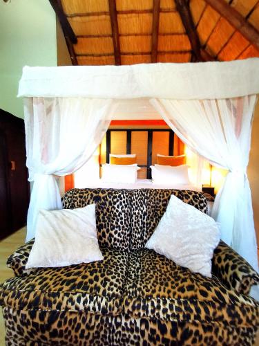 a bedroom with a leopard print bed with a canopy at John and Noleen's place in Marloth Park