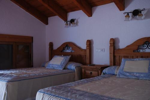 a bedroom with two beds at Casa Rural Las Encinas in Marchena