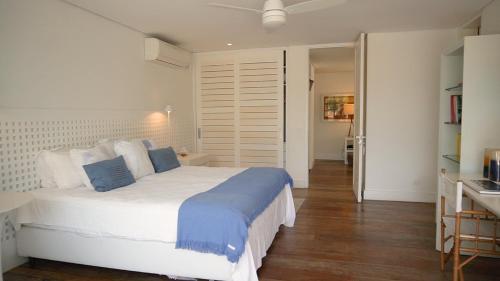 a bedroom with a large white bed in a room at Tropical Contemporary Suites in Paraty
