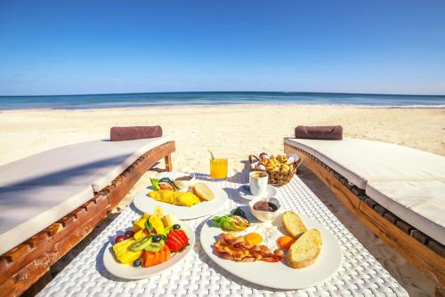 a table with plates of food on the beach at Villa Las Estrellas Tulum - located at the party zone in Tulum