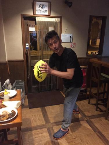 a man holding a yellow ball in a room at Guest house daisho oshiro asobi in Matsue