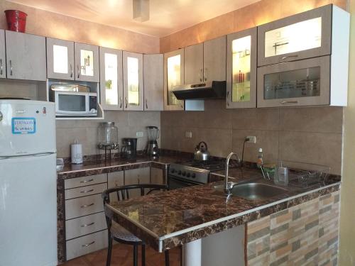 a kitchen with a white refrigerator and a sink at Chakana Family Home Lima Airport in Lima