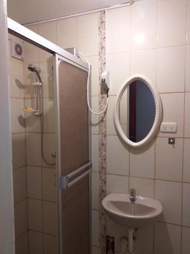 a bathroom with a shower and a sink and a mirror at Chakana Family Home Lima Airport in Lima