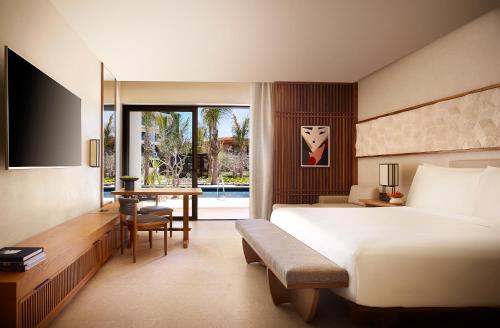 a hotel room with a bed and a desk and a bedroom at Nobu Hotel Los Cabos in Cabo San Lucas
