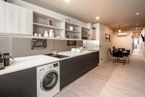 a kitchen with a washer and dryer in it at Central city apartment in Launceston