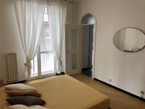 1 dormitorio con cama, espejo y ventana en Appartamento Quadrilocale, en Albenga