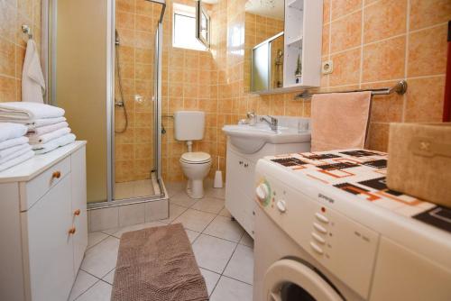 y baño con aseo y ducha. en Apartment Kety - cosy with balcony, en Novalja