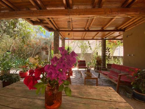 a vase of flowers sitting on a table under a woodenilion at Cabañas Caballieri in Pisco Elqui