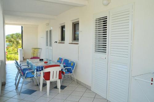 a dining room with a table and blue chairs at Apartments Ruža - free parking in Supetarska Draga