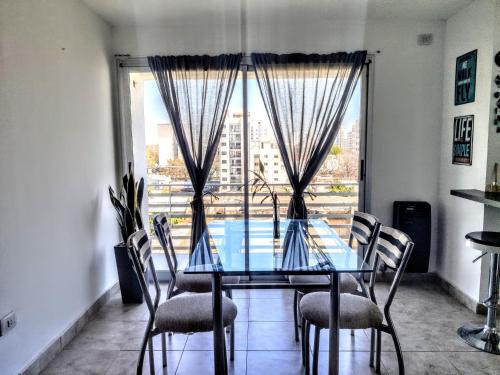 mesa de comedor con sillas y ventana grande en La Plata moderno apart en La Plata