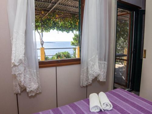 1 dormitorio con ventana y 1 cama morada con toallas en Holiday home Ani - 30 m from beach, en Maslinica