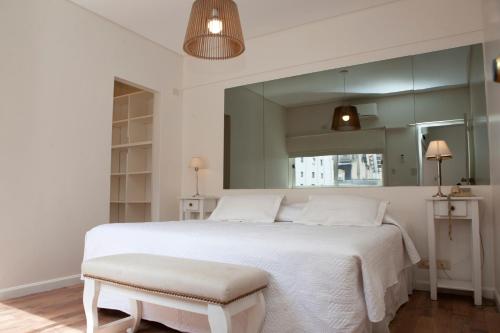 1 dormitorio con cama blanca grande y taburete en Apartamento Canciller en Buenos Aires