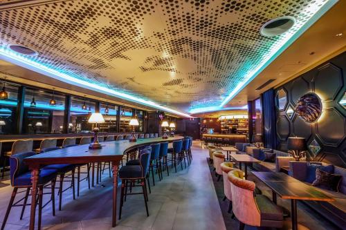 a bar with wooden tables and chairs in a restaurant at The Royal Park Canvas - Osaka Kitahama in Osaka