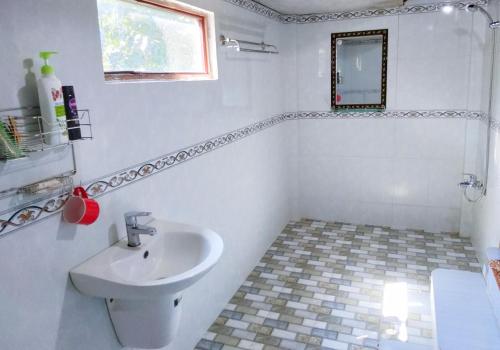 a white bathroom with a sink and a mirror at Green Hope Lodge in Cat Tien