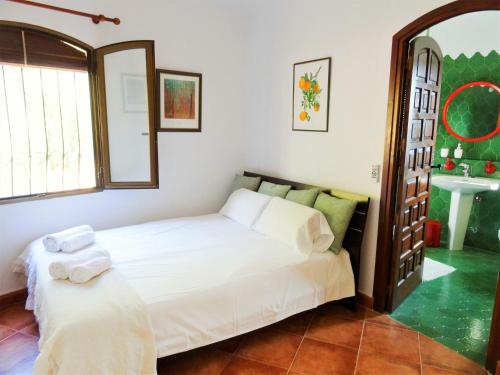 a bedroom with a white bed and a mirror at Casa Kirbo in Altea