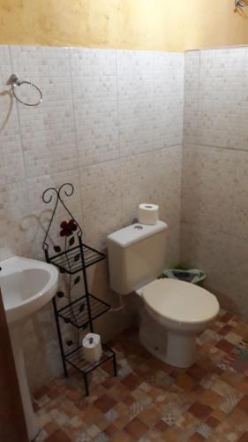 a bathroom with a white toilet and a sink at Pousada Casa do Arco in Santana do Riacho