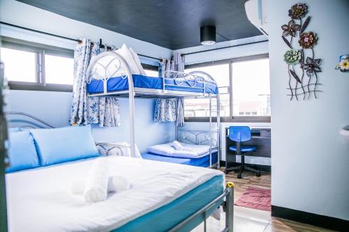 a bedroom with two bunk beds and a desk at Bangkok Canale Home at Khaosarn in Bangkok