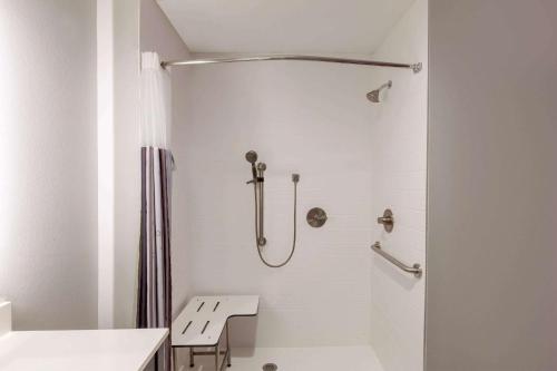 a white bathroom with a shower and a sink at La Quinta Inn & Suites by Wyndham Lafayette Oil Center in Lafayette
